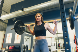 female doing a barbell squat 
